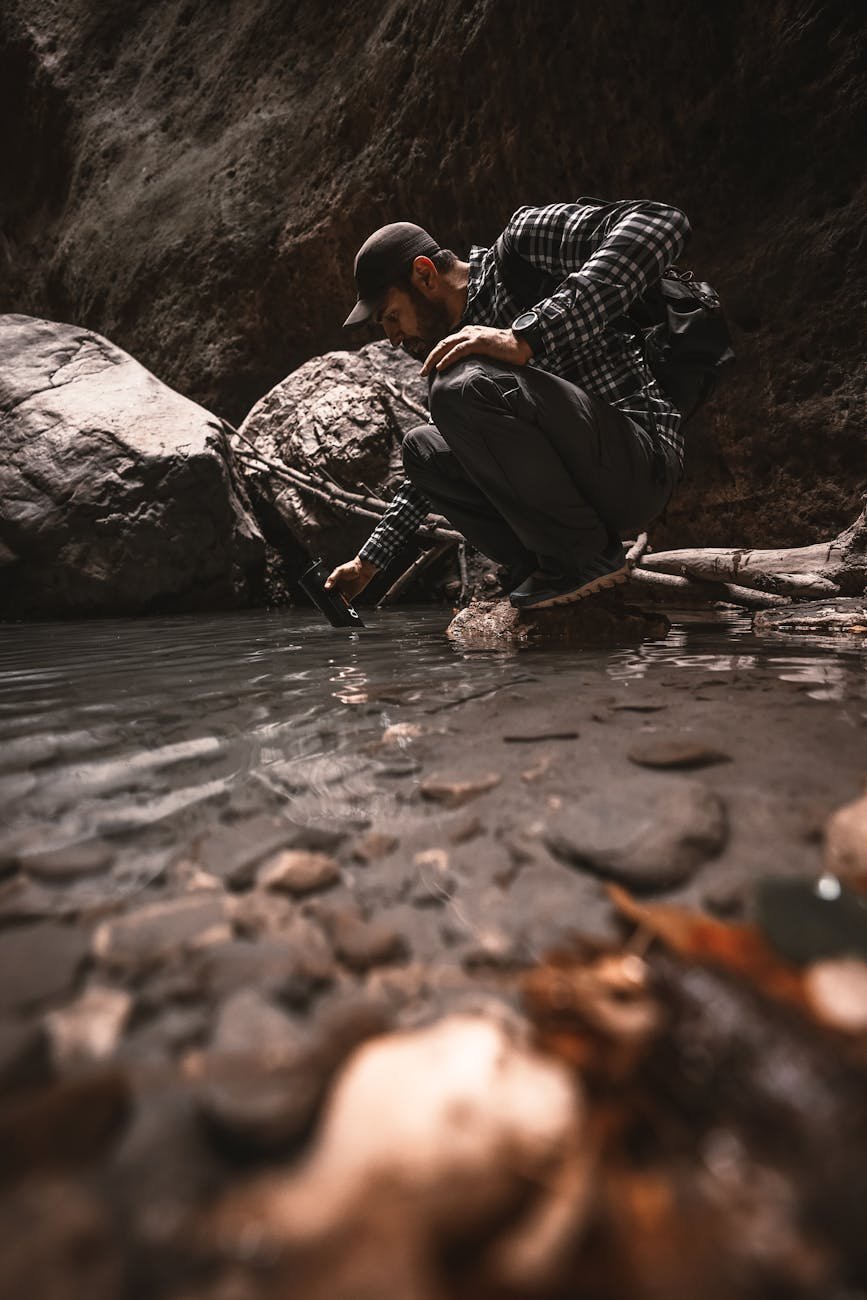 man taking water into an outdoor water purifier